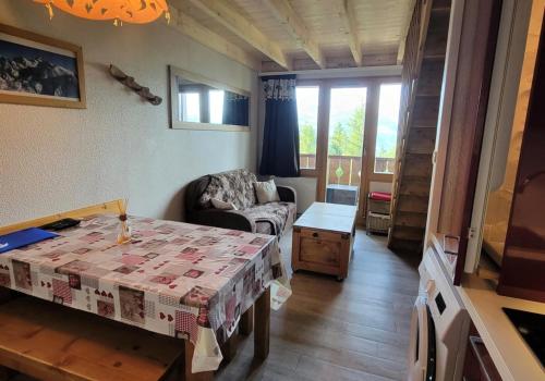 un salon avec une table et une chaise dans l'établissement Résidence Le Bilboquet - Magnifique appartement en duplex MAE-2681, à Aime La Plagne