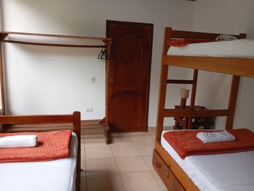 a room with two bunk beds and a door at Wisdom Forest Lodge in Tena