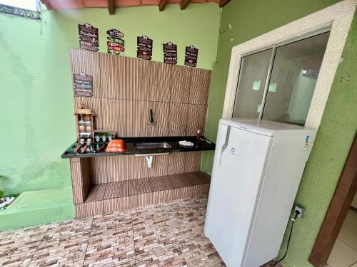 a kitchen with a white refrigerator in a room at Casa Aconchegante 11 pessoas próximo ao aeroporto in Lauro de Freitas