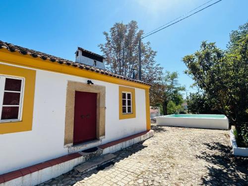 a white and yellow house with a red door at Casa do Martinho in Castelo de Vide