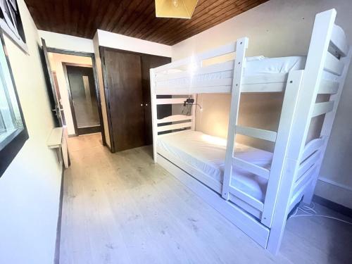 une chambre avec deux lits superposés dans l'établissement Résidence Les Mousquetaires - Appartement cosy skis aux pieds MAE-2544, à Notre-Dame-de-Bellecombe