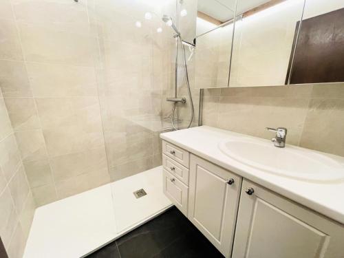 une salle de bain avec un lavabo et une douche dans l'établissement Résidence Les Mousquetaires - Appartement cosy skis aux pieds MAE-2544, à Notre-Dame-de-Bellecombe