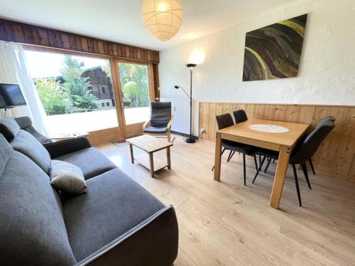 un salon avec un canapé et une table dans l'établissement Résidence Les Mousquetaires - Appartement cosy skis aux pieds MAE-2544, à Notre-Dame-de-Bellecombe