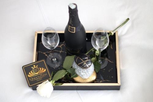 a tray with a bottle of wine and two glasses at Aparthotel "Queen Zina" in Vlasic