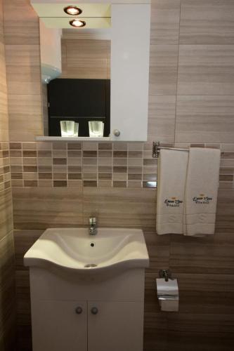 a bathroom with a sink and a mirror and towels at Aparthotel "Queen Zina" in Vlasic