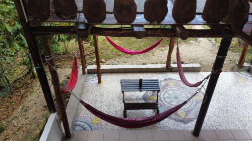 a hammock and a bench on a patio at Wisdom Forest Lodge in Tena