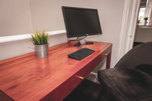 a computer monitor and keyboard on a wooden desk at Spacious 4 Bedroom Flat in Stirling in Stirling