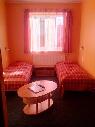 a room with two beds and a table and a window at Jeruzale Hotel in Vilnius