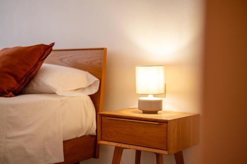 a lamp on a night stand next to a bed at Il Colibrì in Cefalù