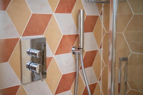 a shower in a bathroom with a hexagonal wall at Il Colibrì in Cefalù