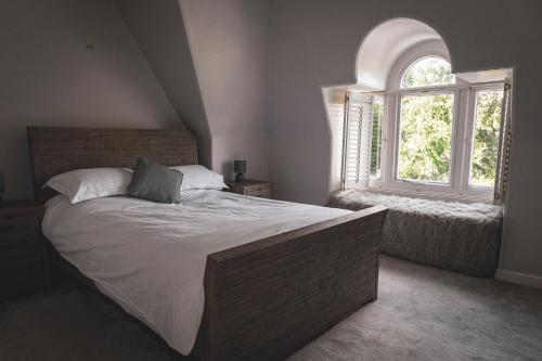 スターリングにあるSpacious 4 Bedroom Flat in Stirlingの大きなベッドと窓のある寝室