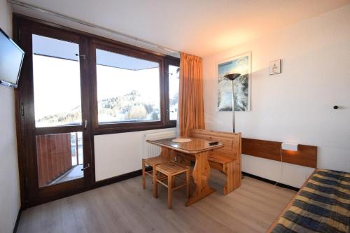 Cette chambre comprend une table, une fenêtre et un lit. dans l'établissement Résidence Le France - Studio 2 pers- LE FRANCE - PLAGNE CENTRE MAE-5994, à Aime La Plagne