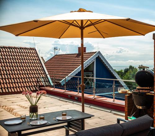 a patio with a table and an umbrella at MANO NIDA in Nida