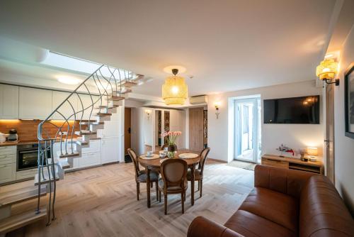 a living room with a dining room table and a kitchen at MANO NIDA in Nida