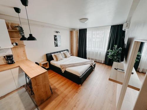 a bedroom with a bed and a desk in it at AGOLL Victoria - self checkin in Reşiţa