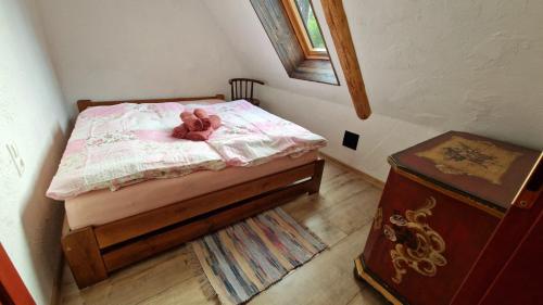 a stuffed teddy bear laying on a bed at Chalúpky Zázrivá in Zázrivá
