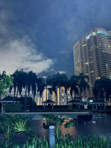 a view of a city skyline with palm trees and buildings at Cozy 1BR Netflix & Alexa w Balcony Free Pool in Manila