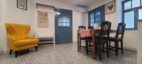 a dining room with a table and a yellow chair at Ötbárány Vendégház in Bezeréd