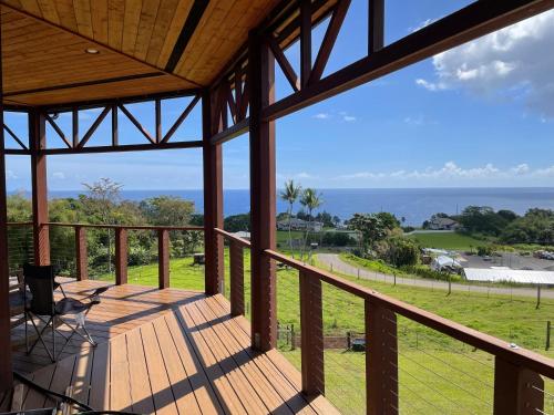 a large wooden porch with a view of the ocean at Hawaii Magic Skies Farmstay in Hilo