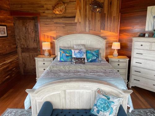 a bedroom with a large white bed with blue pillows at Hawaii Magic Skies Farmstay in Hilo