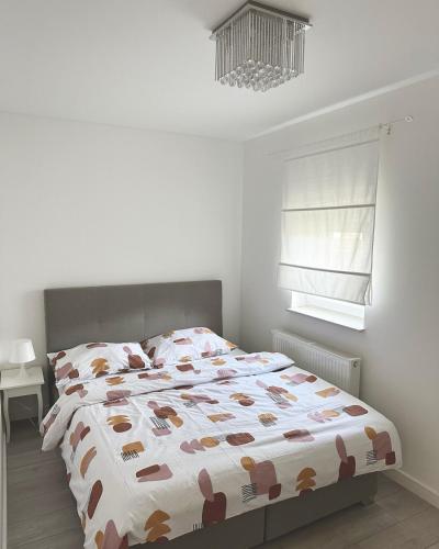 a bedroom with a large bed with a comforter on it at White Lotus in Velika Gorica
