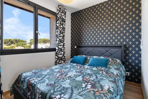 une chambre avec un lit avec une couette bleue et une fenêtre dans l'établissement Rêves bleus, T2 proche plage des sablettes, Clim, Wifi, Place de parking, à La Seyne-sur-Mer