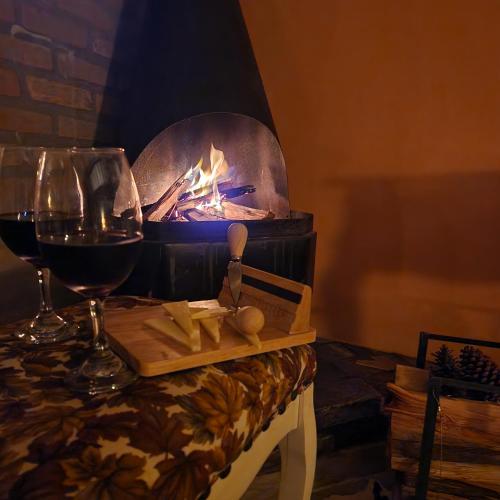 a table with a glass of wine and a fireplace at Pousada Vale Monte Azul in Santo Antônio do Pinhal