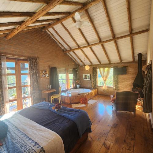 a bedroom with a bed and a tub in a room at Pousada Vale Monte Azul in Santo Antônio do Pinhal