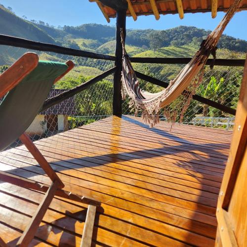 a hammock and a chair on a wooden deck at Pousada Vale Monte Azul in Santo Antônio do Pinhal