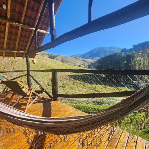 a hammock on a deck with a view at Pousada Vale Monte Azul in Santo Antônio do Pinhal
