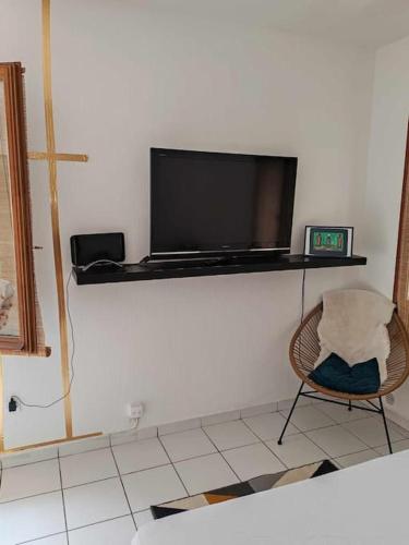 Cette chambre dispose d'une télévision murale et d'une chaise. dans l'établissement or rose, à Toulouse