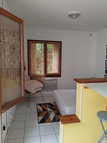 une chambre avec un lit, une fenêtre et une chaise dans l'établissement or rose, à Toulouse