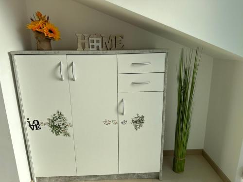 a white dresser in a room with a staircase at Große Ferienwohnung Gästehaus NEUBAU Merzig 120m2 in Merzig