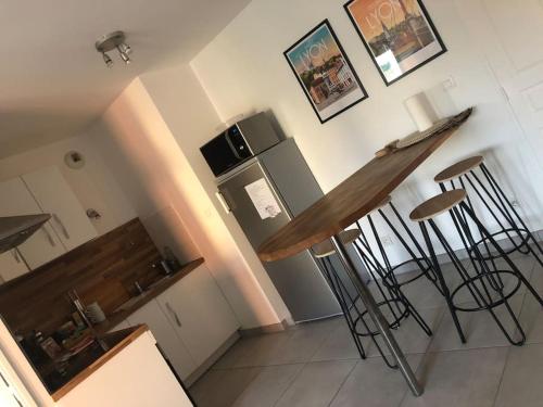 une cuisine avec un comptoir et quelques tabourets de bar dans l'établissement Un balcon à Monplaisir- 4 lits -garage - 47m2, à Lyon