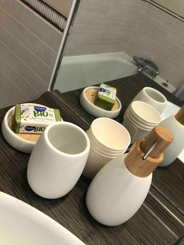 - un comptoir de salle de bains avec des tasses blanches et un miroir dans l'établissement Un balcon à Monplaisir- 4 lits -garage - 47m2, à Lyon