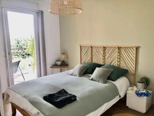 une chambre avec un grand lit avec une grande fenêtre dans l'établissement Un balcon à Monplaisir- 4 lits -garage - 47m2, à Lyon