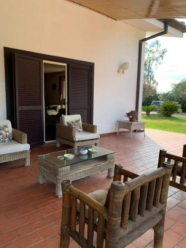 a patio with a couch and a table and chairs at Villa Garden in Sabaudia