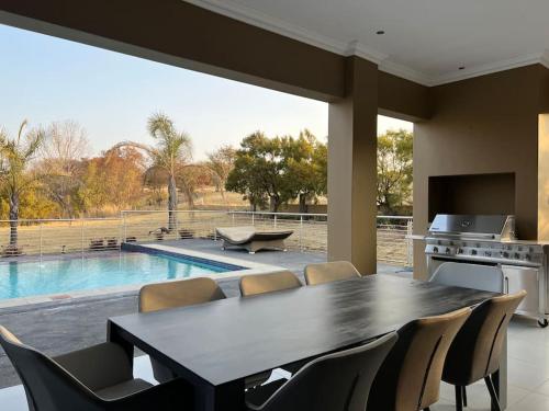 a dining room with a table and chairs and a pool at Hidden Gem in Centurion
