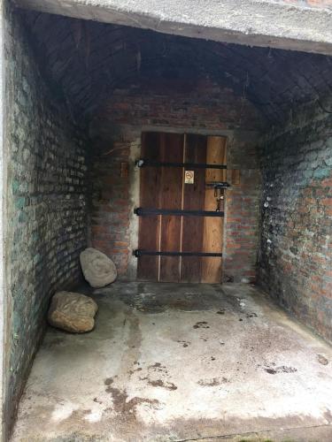 a room with a wooden door in a brick wall at Hotel Museo El Ceibo in San José del Sur