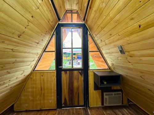 a room with a window in a wooden cabin at El Ensueño Ecohostal & Glamping in Mocoa