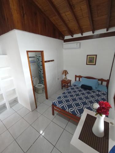a bedroom with a bed and a vase of flowers on a table at Hotel SoleMare in Montañita