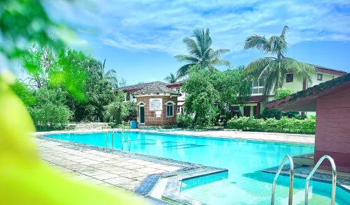 a swimming pool in front of a house at The Gharaundha in Orlim