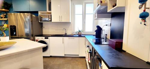 une cuisine avec des armoires blanches et un comptoir noir dans l'établissement Résidence Paris XV Convention - Amazing apartment, à Paris