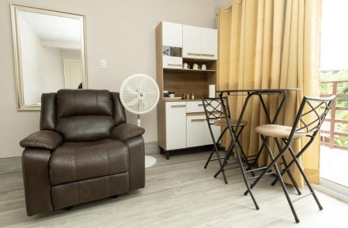 a living room with a chair and a kitchen at D'Rosas Apartments Apto5 in Santiago