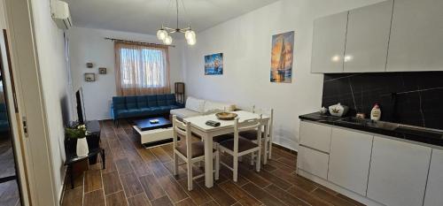 Una cocina y una sala de estar con una mesa y un sofá. en M&M Cozy Home, en Shëngjin