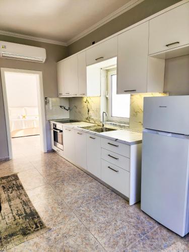 a kitchen with white cabinets and a white refrigerator at Apartment Sweet 2 in Tirana