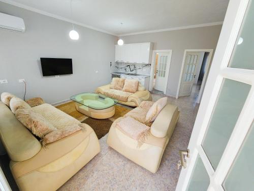 a living room with couches and a flat screen tv at Apartment Sweet 3 in Tirana