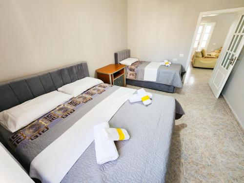 a hotel room with two beds and a hallway at Apartment Sweet 3 in Tirana