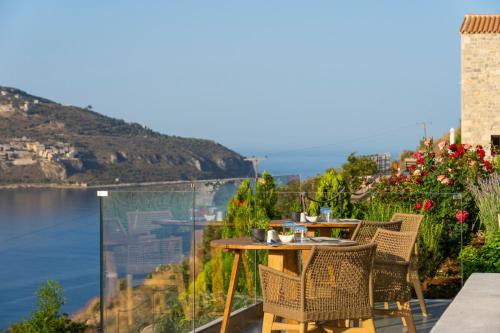 a table and chairs on a balcony overlooking the water at Manifest Boutique Hotel in Oítilon