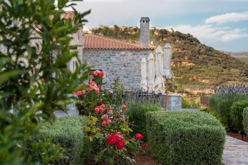 a house with bushes and flowers in front of it at Manifest Boutique Hotel in Oítilon